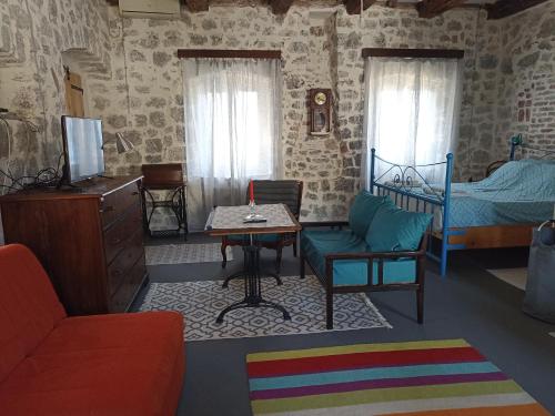 拉多维奇19th century stone house on the seashore的客厅配有床和桌子