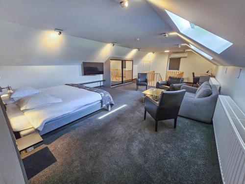 特镇Logis Hôtel Le Menobu的一间卧室配有一张床,客厅配有沙发