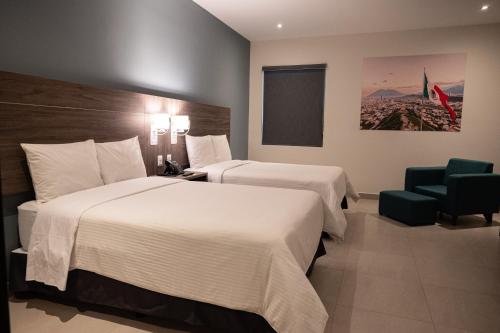 蒙特雷Hotel Centria的酒店客房,配有两张床和椅子