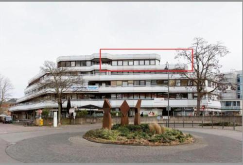 勒沃库森Appartement mit 2 Schlafzimmern-für 3 Personen -Zentral gelegen in Leverkusen Wiesdorf - Friedrich Ebert Platz 5a , 4te Etage mit Aufzug- 2 Balkone -的一座大建筑,前面有雕像