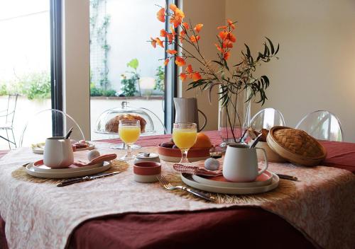 阿尔比Maison d'Hôtes " L'INSTANT D'AILLEURS"的桌子,带桌布和橙汁杯