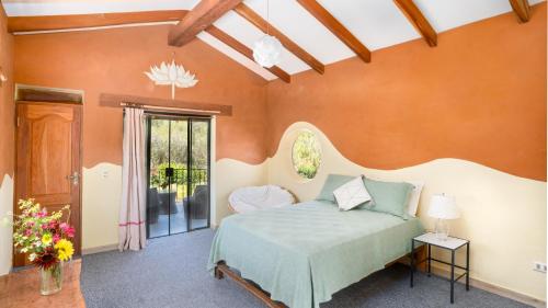 萨迈帕塔Casa Samai Boutique的一间设有床铺的卧室,位于一个拥有橙色墙壁的房间