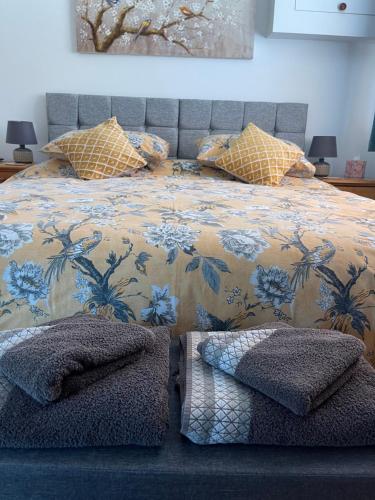East BergholtChestnut Cottage的一间卧室配有一张带花卉床罩和枕头的床
