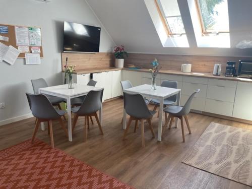 弗罗茨瓦夫Noclegi Budomas Klima-ParkigFree-SmartTv的一间带2张桌子和椅子的用餐室以及一间厨房
