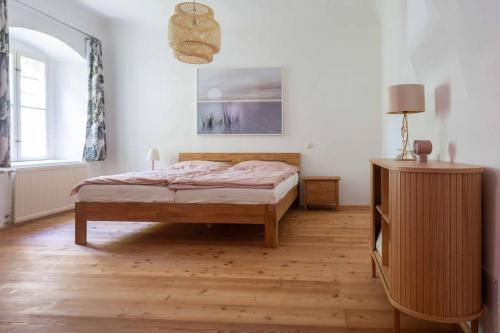 梅尔克Traumhafte Wohnung für 6 Pers.的一间卧室配有一张床,铺有木地板