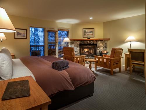菲尔德翡翠湖山林小屋度假村的一间卧室设有一张大床和一个壁炉