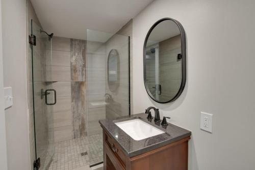 斯科茨博罗6 Pine Luxury Treehouse near Lake Guntersville的浴室配有盥洗盆和带镜子的淋浴