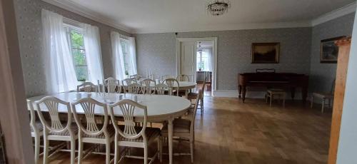 LarvSjötorps Säteris 1600-tals Huvudbyggnad的一间带桌椅和钢琴的用餐室