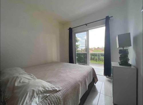 瓜拉图巴Residencial Passos的一间卧室设有一张床和一个大窗户