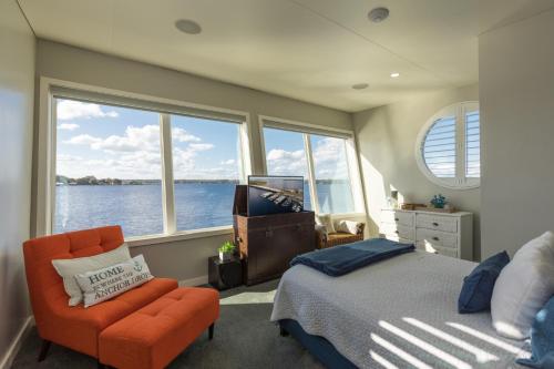 Fleming IslandNew Floating Luxury: Unique Houseboat Retreat的卧室配有床、椅子和窗户。