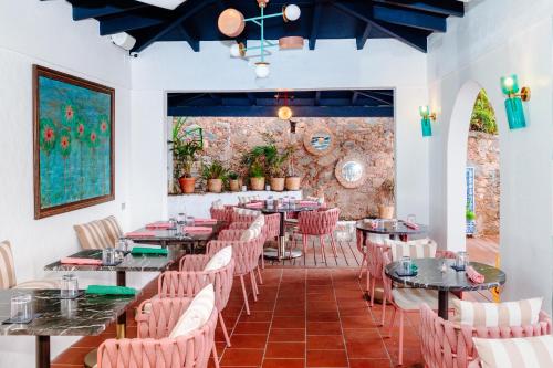 夏洛特阿马利亚The Pink Palm Hotel - Adults Only的一间带桌椅的餐厅以及砖墙