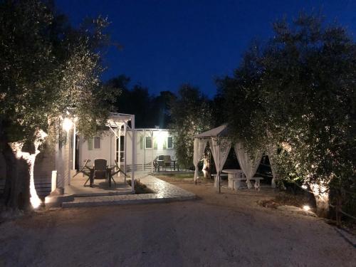 佩斯基奇Pozzo dei Desideri Appartamenti的白色的房子,晚上有帐篷和树木