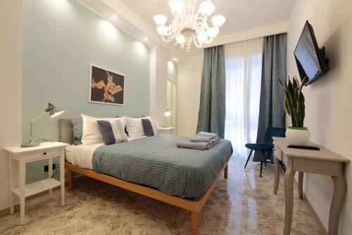 巴里L.T. BARI SUITE _ Locazioni Turistiche _的一间卧室配有一张床、一张书桌和一台电视