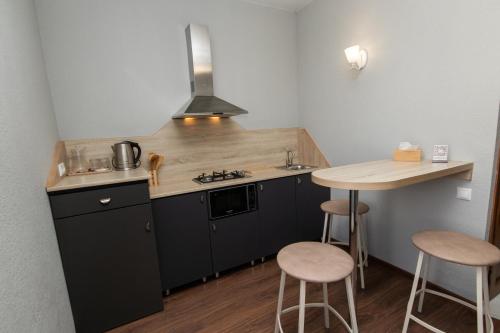 埃里温Hillside Guest House的厨房配有黑色橱柜、桌子和凳子
