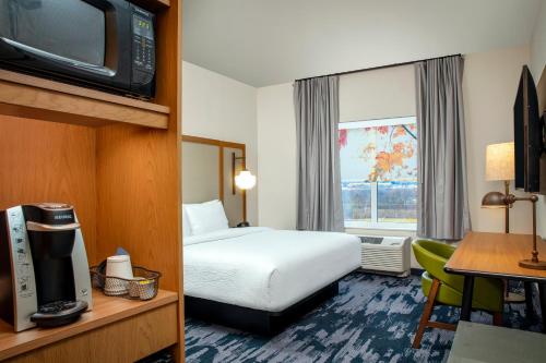 梅卡尼克斯堡Fairfield by Marriott Inn & Suites Harrisburg West/Mechanicsburg的一间酒店客房,配有一张床和一台电视