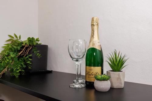 科希策SPAYA JACUZZI centrum apartment - with home cinema & private parking的一瓶香槟和一张桌子上的葡萄酒杯