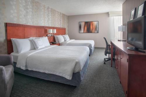 威尔明顿威尔明顿市中心万怡酒店的酒店客房设有两张床和一台平面电视。