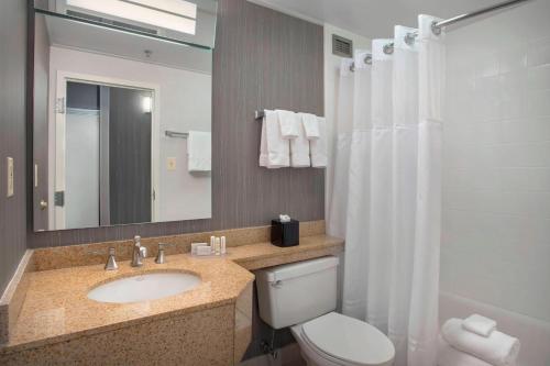 威尔明顿威尔明顿市中心万怡酒店的一间带水槽、卫生间和镜子的浴室