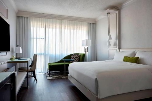 夏洛特夏洛特南方公园万豪酒店的酒店客房配有一张床、一张桌子和一把椅子。