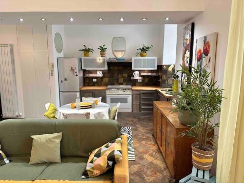 钱皮诺Casa di Lo的一间带绿色沙发的客厅和一间厨房