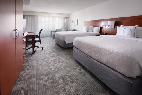 皮尔兰Courtyard Marriott Houston Pearland的酒店客房配有两张床和一张书桌