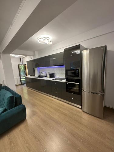 普雷代亚尔Agi’s Apartment Predeal的厨房配有不锈钢冰箱和黑色橱柜