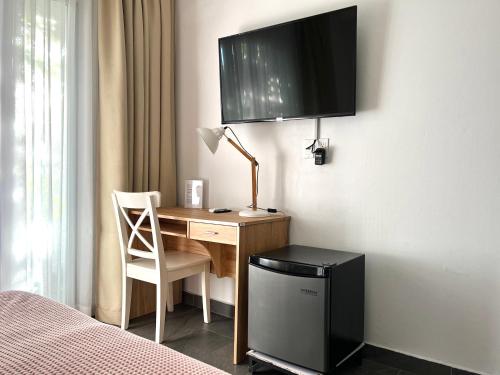 帕拉马里博Villa Famiri Boutique hotel的卧室配有一张桌子,墙上配有电视