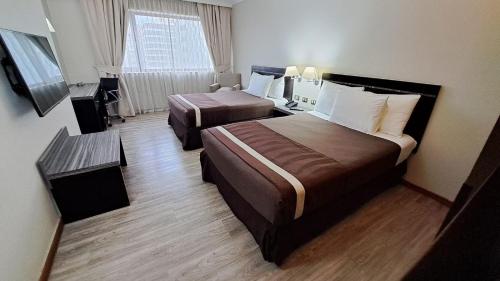 圣地亚哥圣地亚哥阿尔马格罗普罗维登酒店的酒店客房设有两张床和窗户。