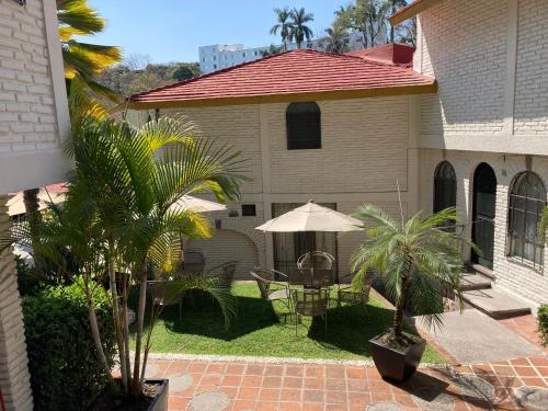 库埃纳瓦卡伊勒贝尔酒店的房屋设有带桌子和遮阳伞的庭院