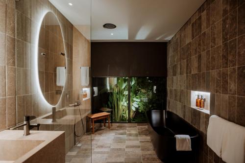 麦德林Hotel El Zarzo的一间带大镜子和浴缸的浴室