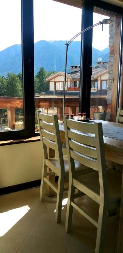 拉兹洛格ALL VIEW in Golf Resort的两把白色椅子坐在桌子旁,边有窗户