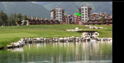 拉兹洛格ALL VIEW in Golf Resort的一座高尔夫球场,毗邻一片水体,拥有建筑