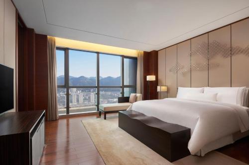 重庆 重庆解放碑威斯汀酒店的一间卧室设有一张大床和一个大窗户