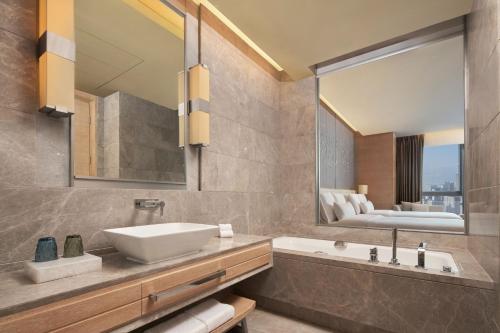 重庆 重庆解放碑威斯汀酒店的一间带水槽、浴缸和镜子的浴室