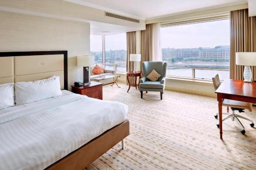 哥本哈根哥本哈根万豪酒店的大型酒店客房设有一张床、一张书桌和一张书桌