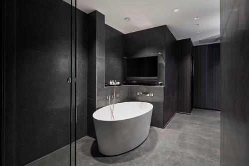 哥本哈根哥本哈根万豪酒店的带浴缸的浴室和电视。