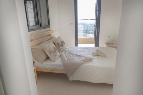 阿卡A modern apartment in Acre的一间卧室设有一张床和一个窗口