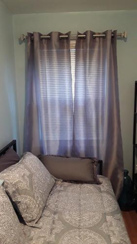 LaureltonJfk Resorts World的一间卧室配有一张带紫色窗帘的床