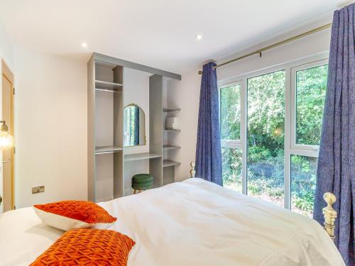 科尔福德Greenacres Cabin的一间卧室配有带两个枕头的床和窗户