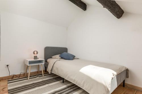波尔图Bento Guest House的一间卧室配有一张床和一张边桌