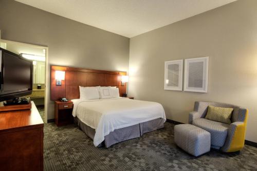麦卡伦麦卡伦万怡酒店的配有一张床和一把椅子的酒店客房