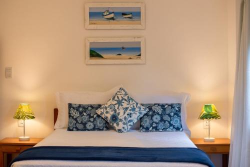 布希奥斯Villa Bella Ferradura的一间卧室配有一张带蓝色和白色枕头的床