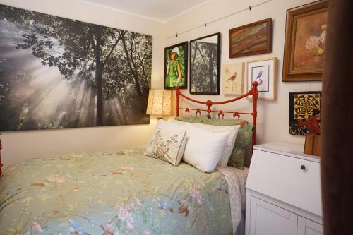 旧金山Perfect Location - 4BD,1BA - Restored Redwood Home的卧室配有一张床,墙上挂有绘画作品