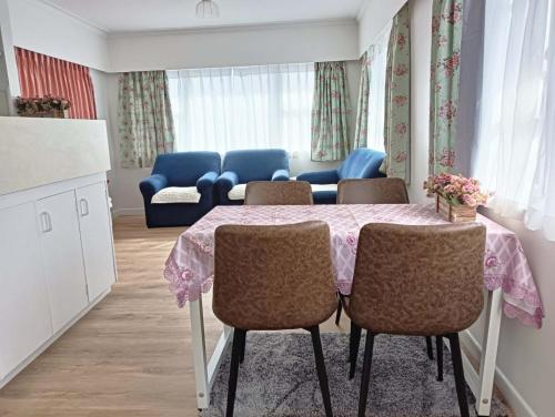 汉密尔顿Melville Guest House near Waikato Hospital的用餐室配有桌椅和沙发