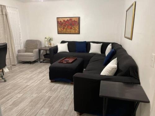 伊丽莎白城Comfort & Quiet in a central location的客厅配有黑色沙发和椅子