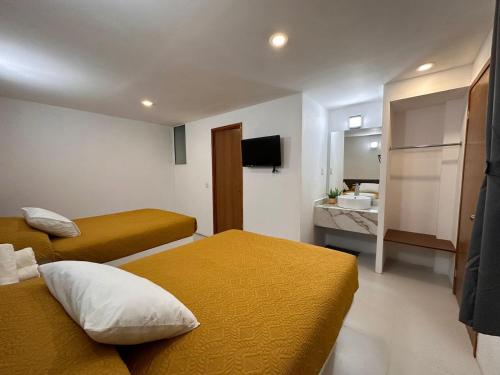 萨卡特兰Hotel Quinta Luna Zacatlán的酒店客房带两张床和一间浴室