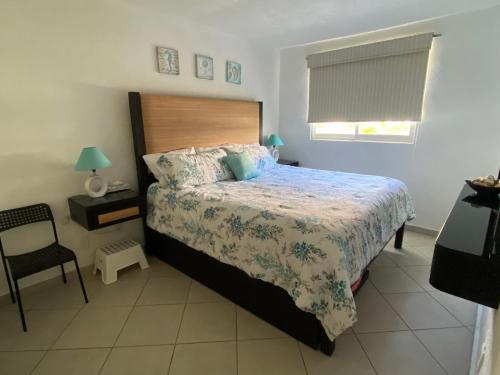阿卡普尔科Acapulco Diamante hermoso departamento的一间卧室配有一张床和一把椅子