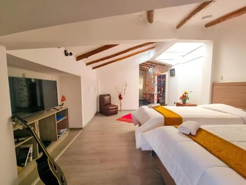 库斯科Apart Hotel El Puma的客房设有三张床和一台平面电视。