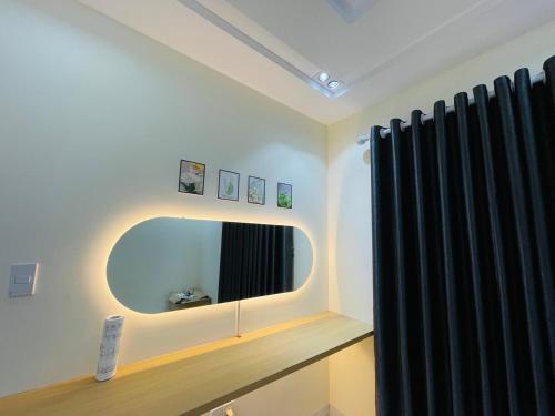 海防Basic Guest House Hải Phòng的浴室设有镜子和黑色窗帘
