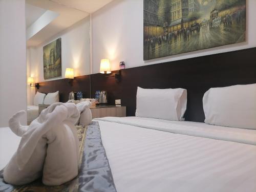 芭东海滩Amici Miei Guest House的一间卧室配有一张大床和大象床头板